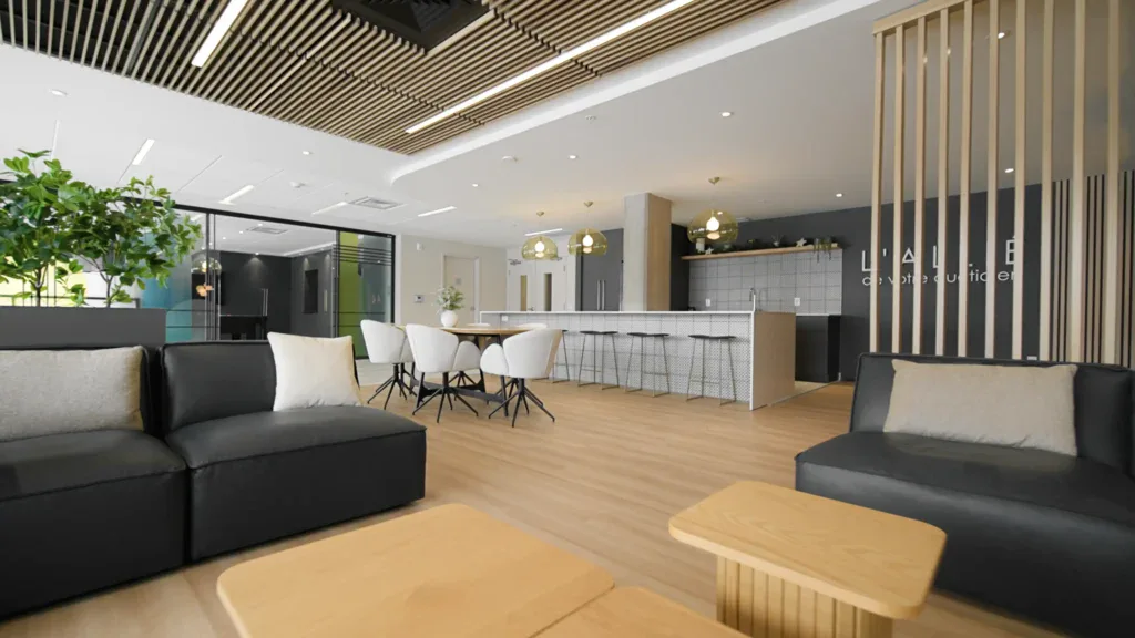 Espace de détente moderne avec canapé, tables en bois et cuisine ouverte